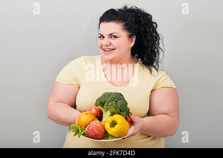 Übergewichtige Frau mit frischem Gemüse. Konzept gesunde Ernährung Stockfoto