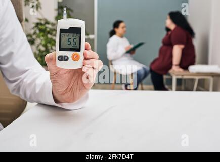 Diabetes-Untersuchung. Der Endokrinologe überprüft den Blutzucker einer Frau. Übergewicht und Diabetes Stockfoto