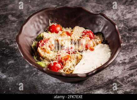 Caesar-Salat. Saftige Scheiben Hühnersteak, frischer Salat, Tomaten, gerösteter Speck, Parmesan Stockfoto