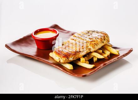 Hühnersteak mit pommes frites mit Honig-Senf-Sauce. Stockfoto