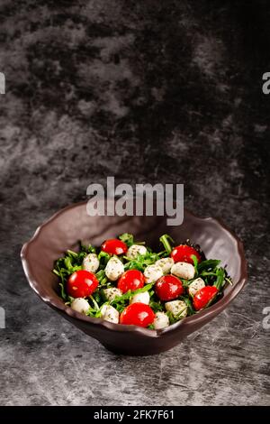 Caprese-Salat. Frische Rucola, Kirschtomaten, saftige Mini-Mozzarella und ein Dressing aus Orangano und Olivenöl Stockfoto