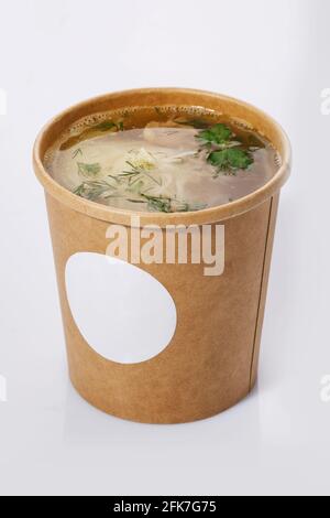 Suppe in einer Tasse recyceltem Papier isoliert auf weißem Hintergrund. Konzept der Bio-Lebensmittelverpackung. Stockfoto