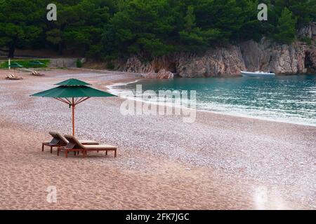 2 Liegestühle mit Sonnenschirm am Strand. Perfektes Urlaubskonzept. Küstenlandschaft. Entspannend. Stockfoto