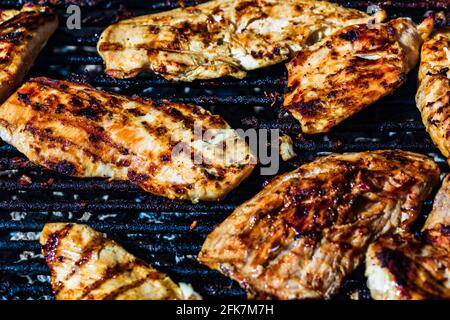 Blick von oben auf Hühnchen- und Schweinesteak, gegrillt auf einem Holzkohlegrill Stockfoto