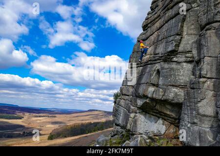 Männlicher Bergsteiger auf dem klassischen Black Slab, Stanage Edge, Peak District, Derbyshire, Großbritannien Stockfoto