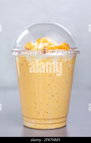 Süßer Milchcocktail mit Popcorn in einem Plastikglas. Stockfoto