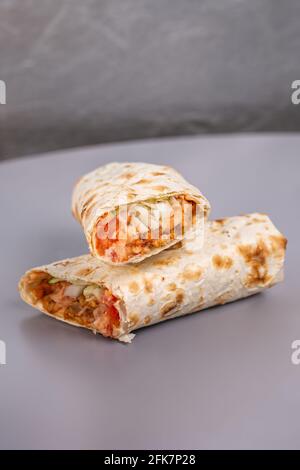 Döner in Pita-Brot in einem Schnitt auf grauem Hintergrund. Stockfoto