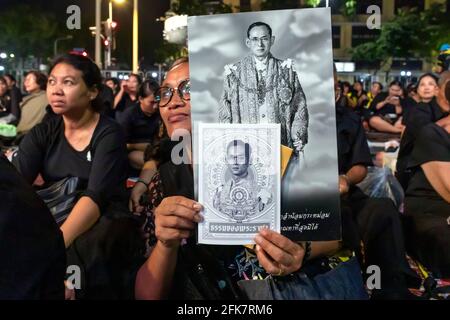 Trauernde in Schwarz mit Fotos von König Bhumibol bei der Trauerfeier in Bangkok, Thailand Stockfoto