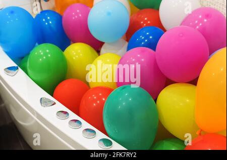 Die Badewanne ist mit bunten Luftballons gefüllt. Stockfoto