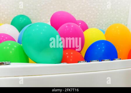 Die Badewanne ist mit bunten Luftballons gefüllt. Stockfoto