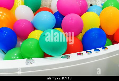 Die Badewanne ist mit bunten Luftballons gefüllt. Stockfoto