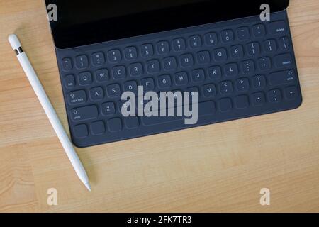 Schwarzer Pro-Tablet-Computer, der auf einer tragbaren Tastatur neben angeschlossen wird Weißer Bleistiftstift auf Holzhintergrund mit Copyspace Stockfoto