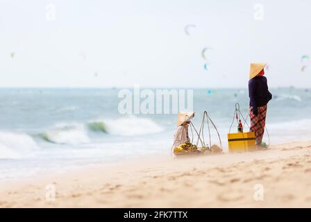 Vietnamesische Frau, die am Strand von Mui Ne Früchte verkauft. Vietnam. MUI Ne weißer Sandstrand in Vietnam. Stockfoto