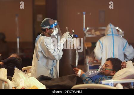 Delhi, Indien. April 2021. Ein Mitarbeiter des Gesundheitswesens, der einen persönlichen Schutzanzug (PSA) trägt, betreut einen Covid19-Patienten auf der Isolationsstation in Neu-Delhi. Ein Bankettsaal, der vorübergehend zu einer Covid19-Station für Coronavirus-Patienten umgebaut wurde. Indien hat die höchste eintägige Spitze bei einer Coronavirus-Infektion verzeichnet. Kredit: SOPA Images Limited/Alamy Live Nachrichten Stockfoto