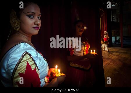 Kandy, Sri Lanka: Eine Tänzerin der Kandyan Arts Association versteckt sich hinter dem Vorhang, bevor sie die Bühne für die Abendshow betreten Stockfoto