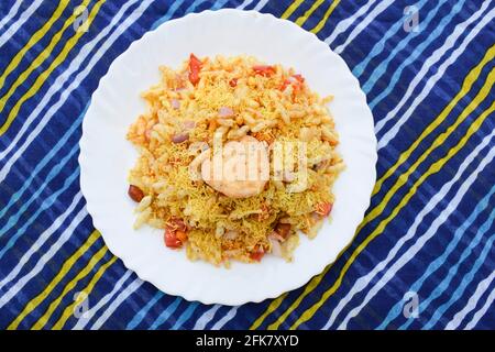 Bhelpuri, indisches beliebtes Straßenessen aus Puffreis und sev. Indische Teezeit-Snacks werden auf einem Teller auf dem Tisch serviert. Besondere berühmte Chaat Artikel von I Stockfoto