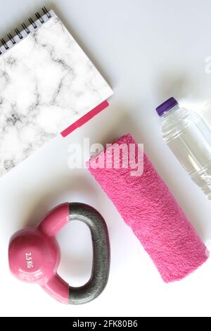 Sport feminine Accessoires, flaches Lay, rosa Kurzhantel-Notizblock für Nachbau, Kopierfläche. Fitnesszubehör und -Ausrüstung in rosa femininer Farbe. Fitness Stockfoto