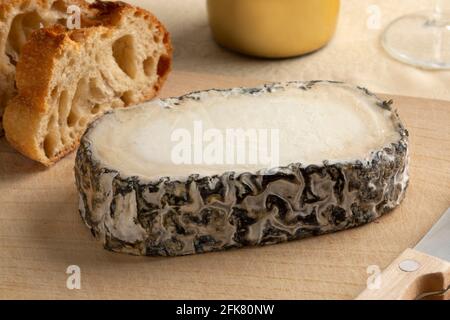 Ein Stück spanischen handwerklichen Monte Enebro-Käses aus nächster Nähe Ein Schneidbrett Stockfoto