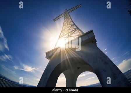 Weitwinkelaufnahme des Steel Monument Cross. Low-Angle-Aufnahme des Millennium Cross auf dem Gipfel des Berges in Limanowa, Polen gegen dramatische Sonnenstrahlen während der da Stockfoto