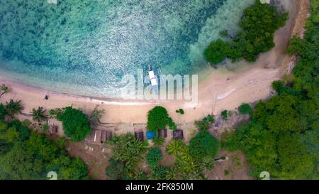 Drohnenansicht eines tropischen Strandes mit einem einheimischen Boot Stockfoto