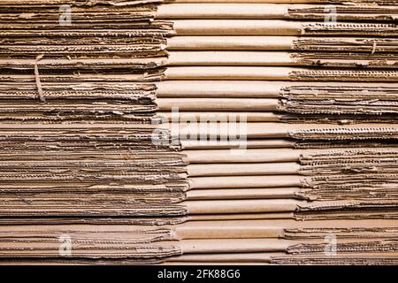 Große Kartonstapel liegen in einem Lagerhaus übereinander. Konzept der Lagerung von Sachen und umweltfreundlichem Material. Verlängerbar Stockfoto