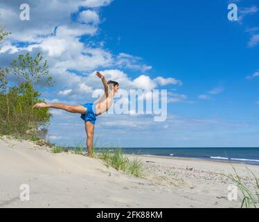 Region Königsberg, Ostsee, Russland, 6. Juni 2020. Ein junger Athlet am Strand. Gymnastikkurse auf See. Am Strand wird geladen. Stockfoto