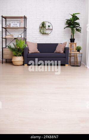 Interieur mit Sofa, Tisch, Regal und Pflanzen über Ziegelwand - kopieren Platz auf dem Boden Stockfoto