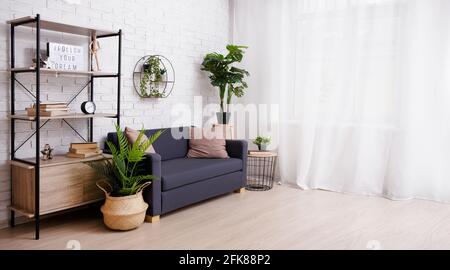 Innenraum eines Zimmers mit Sofa, Regal, Pflanzen und Fenster Stockfoto