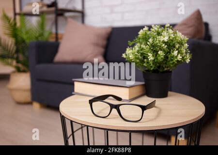 Lesekonzept - Gläser und Buch auf dem Tisch im Innenraum Stockfoto