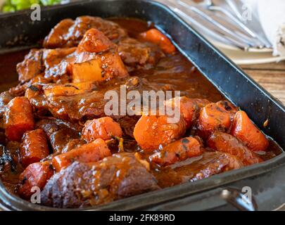 Ein Backblech mit köstlichen geschmorten Rinderschenkeln, Sauce und Karotten. Nahaufnahme Stockfoto