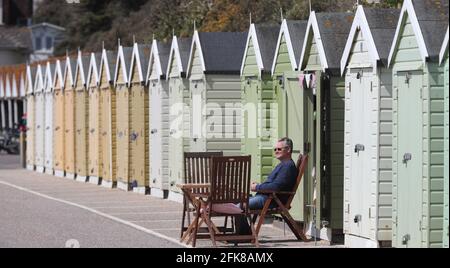 Bournemouth, Großbritannien. April 2021. Ein Mann genießt seine Strandhütte an einer sonnigen Küste von Bournemouth vor dem Feiertagswochenende. Kredit: Richard Crease/Alamy Live Nachrichten Stockfoto