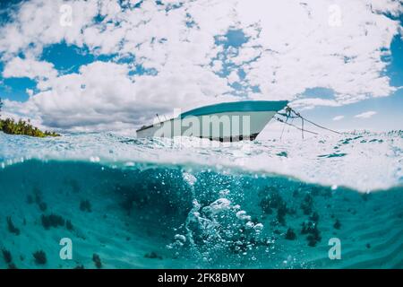 Tropischer transparenter Ozean mit weißem Boot in Mauritius. Geteilte Ansicht mit Blasen im Wasser. Stockfoto