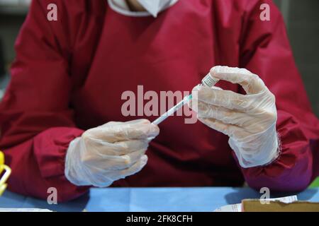 Krankenschwester in der Apotheke während der Vorbereitung einer Spritze für die Verabreichung des pfizer-biontech-Impfstoffs.Apotheke in einem Raum von Real Bosco eingerichtet. Stockfoto