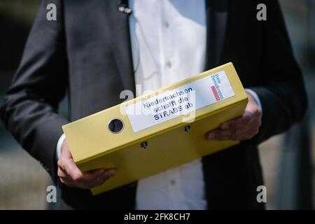 Hannover, Deutschland. April 2021. André Grote, Initiator einer Online-Petition gegen Straßenbaugebühren in Niedersachsen, hält eine Mappe mit der Aufschrift: "Niedersachsen schafft STRABS ab" in den Händen. Quelle: Ole Spata/dpa/Alamy Live News Stockfoto