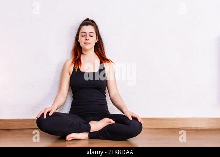 Frau übt Yoga und meditiert in der Lotus Position Stockfoto