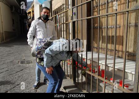 Die Gläubigen legten Blumen, Kerzen, Luftballons vor das geschlossene Tor des Heiligtums der Madonna del Carmine, genannt "die Hühner" . Stockfoto