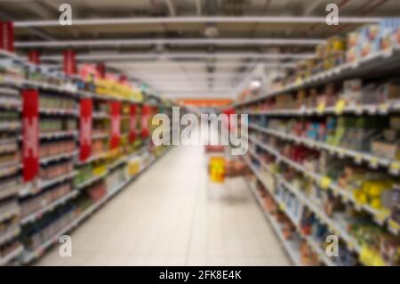 Abstrakt verschwommenes Supermarktschiff mit bunten Regalen. Stockfoto