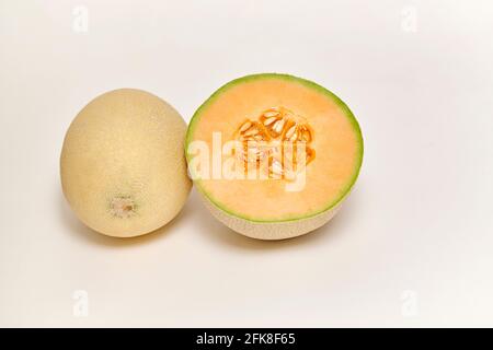 Ganze und geschnittene japanische Melone, Honigmelone oder Cantaloupe (Cucumis melo) auf weißem Hintergrund Stockfoto