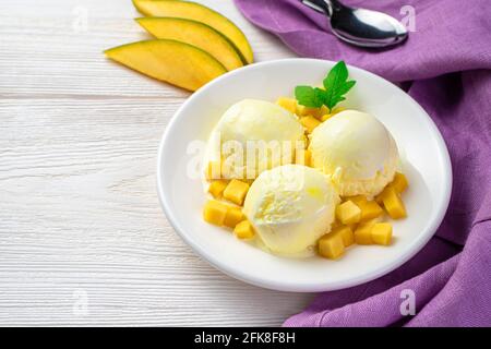 Mango-Eiskugeln und Mangoscheiben auf weißem Hintergrund mit Platz zum Kopieren. Stockfoto