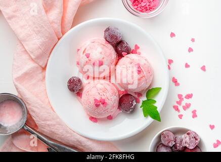 Obst- und Speiseeis mit gefrorenen Kirschen auf hellem Hintergrund. Draufsicht, horizontal. Stockfoto