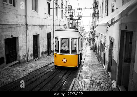 Gelbe Straßenbahn an der alten Straße in Lissabon. Skizzieren Sie ein Schwarzweißbild. Stockfoto