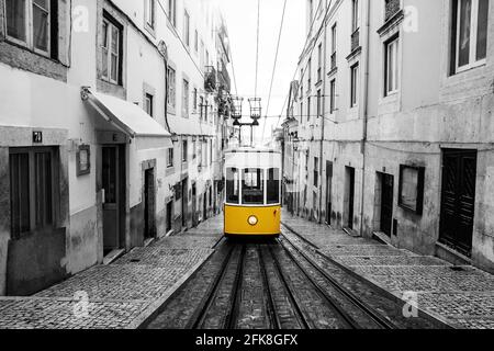 Gelbe Straßenbahn an der alten Straße in Lissabon. Skizzieren Sie ein Schwarzweißbild. Stockfoto