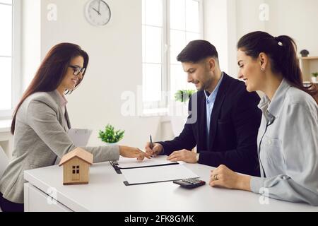 Zufriedene Millennial paar Kunden Unterzeichnung Immobilien-Vertrag Stockfoto