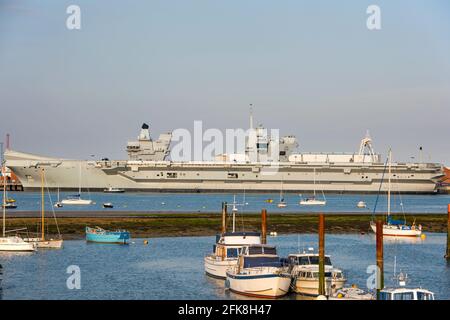 Der Flugzeugträger der Royal Navy HMS Prince of Wales (R09), der am 27. April 2021 bei Sonnenuntergang im Hafen von Portsmouth von Gosport, Großbritannien, gesehen wurde. Stockfoto