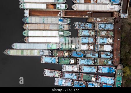 Viele verlassene Transportkähne liegen nebeneinander am Kai. Binnenschifffahrt. Stockfoto