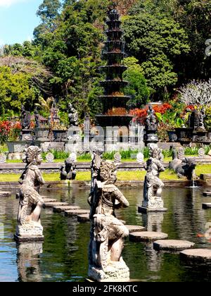 Der erstaunliche Wasserteich, voll von exotischen Steinskulpturen und einem hohen Brunnen. Im Tirta Gangga Water Palace in Bali, Indonesien. Stockfoto