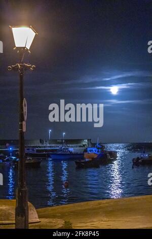 Ein Erntemond, der bei einer Flut im Minehead Harbour, Somerset, Großbritannien, aufsteigt Stockfoto