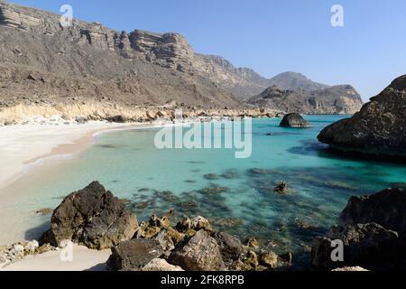 Fazaya Beach und die vertikalen Klippen von Mughsail, die zur westlichen Salalah-Ebene führen. Gouvernement Dhofar, Oman Stockfoto