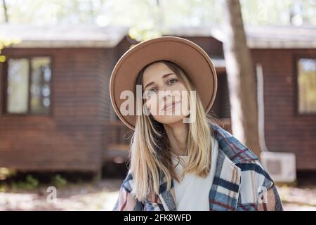 Junge stilvolle kaukasische Frau 30-35 Jahre alt in legerer Kleidung hemd und Cowboy Hut genießen das Leben am Morgen im Sommer Abenteuer im Camping Stockfoto