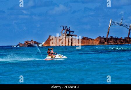 Dominikanische Republik, Wassermoped mit Urlaubern und Schiffsrack, vor der Kueste von Punta Cana. Stockfoto